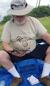 Dave KB3RAN sitting on a up-turned milk crate working PSK31 using a tablet.