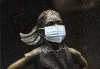 A surgical mask on the Fearless Girl statue outside the New York Stock Exchange